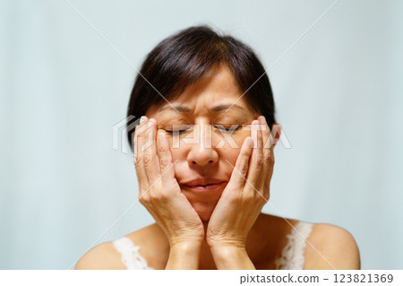Middle-aged woman with hand on cheek Middle-aged woman with hand on cheek 123821369