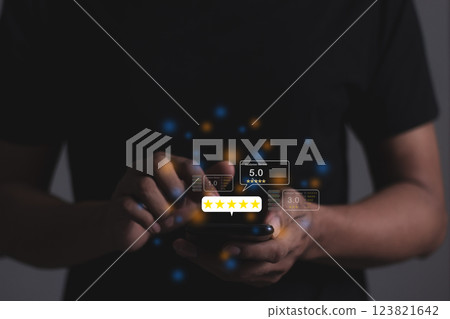 Young Man hand holding Smart Phone with five star to review and give 5 stars Young Man hand holding Smart Phone with five star to review and give 5 stars 123821642