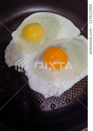 Yolks of different shades in pan from farm and from factory farmed chickens 123822068