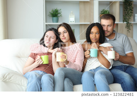Two interracial couples drinking and relaxing at home 123822481