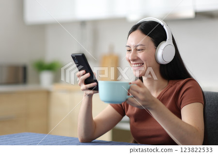 Happy asian woman watching media on phone at breakfast 123822533