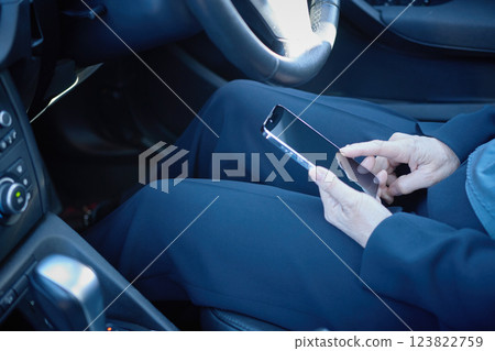 一名身穿西裝的中年女子停下來操作她的智慧型手機 123822759