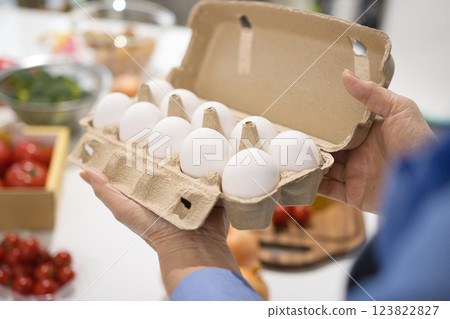Middle-aged woman's hand holding fresh eggs 123822827