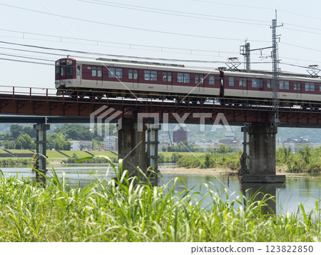 一列近鐵明治線列車正在穿越大和川上的鐵路橋 一列近鐵明治線列車正在穿越大和川上的鐵路橋 123822850