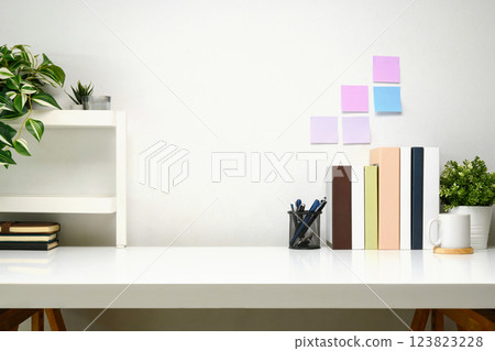 Clean and organized workspace with books, stationery, and decorative plants 123823228