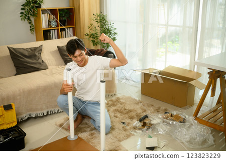 Happy man raising fist in triumph, celebrating his successfully assembling table 123823229