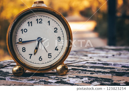 Vintage Clock on a Rustic Wooden Table Outdoors Vintage Clock on a Rustic Wooden Table Outdoors 123823254