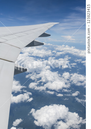 View of the plane's wing and beautiful clouds through the window during the flight. 123823415