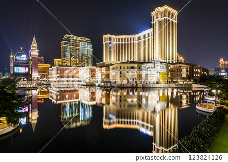 Beautiful night view of Venetian Gothic-style buildings in Cotai, Macau with beautiful reflections of the majestic buildings in the water, owned by the American Las Vegas Sands company. Beautiful night view of Venetian Gothic-style buildings in Cotai, Macau with beautiful reflections of the majestic buildings in the water, owned by the American Las Vegas Sands company. 123824126