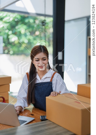 Excited young woman celebrating success while using computer laptop to see data delivery products customer profit Selling products of This month 123824194