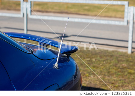 A blue car with a white antenna on top of it 123825351
