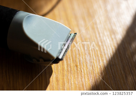 A detailed closeup of a hair clipper placed on a wooden table A detailed closeup of a hair clipper placed on a wooden table 123825357