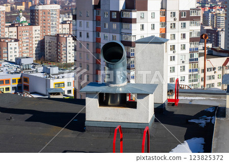 A chimney on a building with a city skyline in the background 123825372