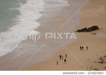 People walking along of Lourtuais beach. People walking along of Lourtuais beach. 123825803