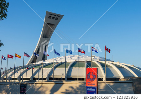 Montreal, Quebec, Canada - August 10 2021 : Montreal Olympic Stadium (The Big O) with flags of the world. 123825916