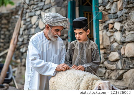 Muslim father teaching his young son how to prepare a sheep for the religious festival of eid al adha 123826063