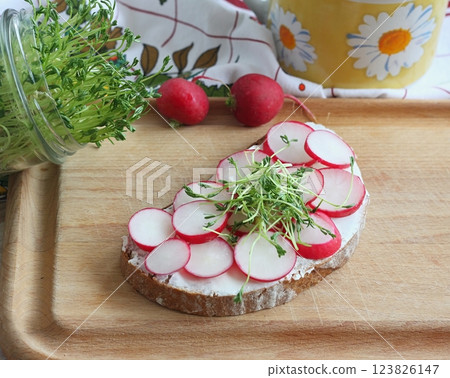 Slice of sourdough bread with fresh radish on the cutting board. Slice of sourdough bread with fresh radish on the cutting board. 123826147