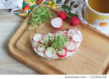 Slice of sourdough bread with fresh radish on the cutting board. Slice of sourdough bread with fresh radish on the cutting board. 123826148