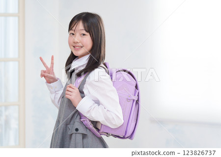 Elementary school student carrying a school bag (peace sign) 123826737
