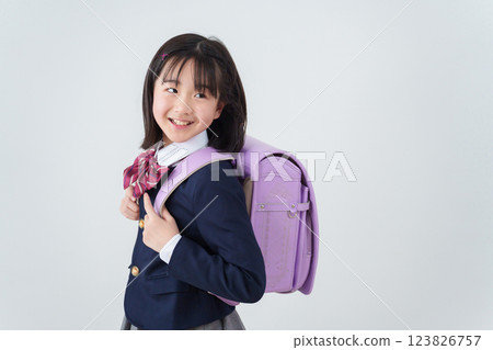 Elementary school student carrying a school bag Elementary school student carrying a school bag 123826757