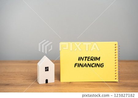 Interim financing in real estate concept. Short-term loan or financial arrangement designed to provide temporary funding until a more permanent source of financing is secured. Notes and house 123827182
