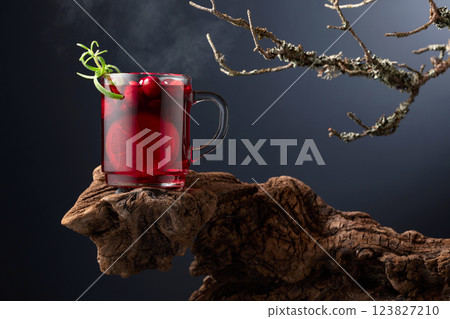 Hot drink with cranberries, lime, and rosemary on a old wooden snag. 123827210