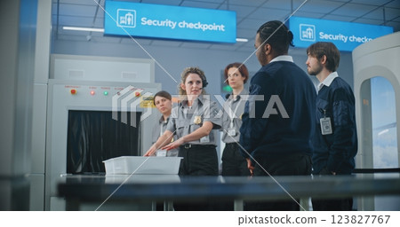 Female Security Officer Instructs Airport Staff About Scanning Process on Metal Detector 123827767