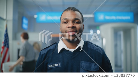 Airport Security Checkpoint: Portrait of TSA Worker Smiling and Looking at Camera Airport Security Checkpoint: Portrait of TSA Worker Smiling and Looking at Camera 123827770