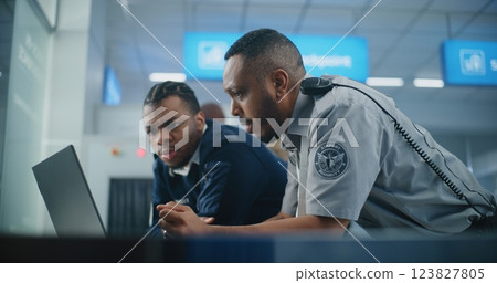 Airport Security Checkpoint: Security Officers Using Laptop Computer and Talking Airport Security Checkpoint: Security Officers Using Laptop Computer and Talking 123827805