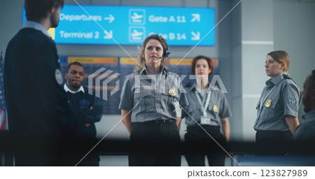 Airport Staff Training: Female Security Officer Wearing Headset Giving Instructions to Team of Workers Airport Staff Training: Female Security Officer Wearing Headset Giving Instructions to Team of Workers 123827989