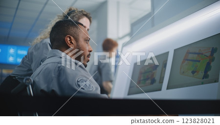 Two Security Officers Analyzing X-ray Scanning Images of Baggage on Computer Screens Two Security Officers Analyzing X-ray Scanning Images of Baggage on Computer Screens 123828021