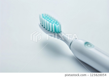 Modern electric toothbrush with soft, aqua bristles displayed against a pristine white background, emphasizing dental hygiene and technology fusion 123828054