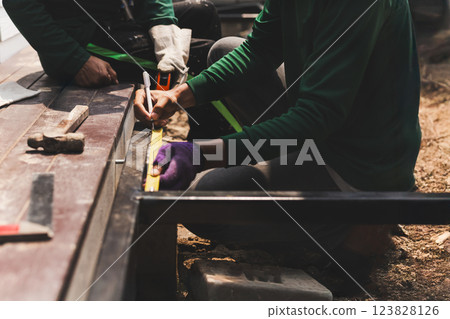Ironworker measuring with hand holding a pen in building site Ironworker measuring with hand holding a pen in building site 123828126