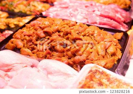 Meat department of store sells chicken meat marinated with addition of curry seasoning. 123828216