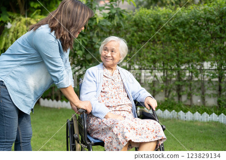 Caregiver help and care Asian senior woman patient sitting on wheelchair at nursing hospital ward, healthy strong medical. 123829134
