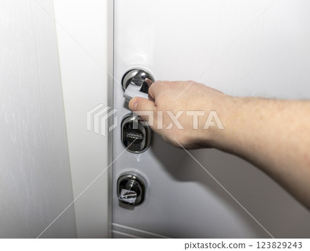 White door with metal handle and locks as a part of interior design 123829243