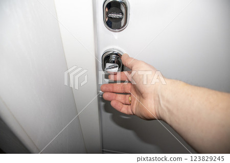 White door with metal handle and locks as a part of interior design 123829245