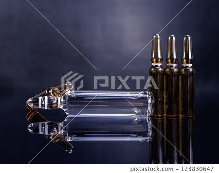 Ampoules with medicine on glossy black background Ampoules with medicine on glossy black background 123830647