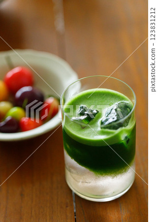 Cup of fresh matcha tea, green tea and colorful peach fruit shape Plating balls, Thailand style dessert on wooden table. 123831212