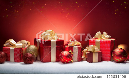 A red box with a gold bow sits on a table next to several other red boxes 123831406