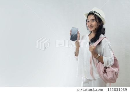 Asian woman wearing straw hat and backpack holding black screen cellphone. back to school via timetable app or woman who wants to travel, using isolated ads Asian woman wearing straw hat and backpack holding black screen cellphone. back to school via timetable app or woman who wants to travel, using isolated ads 123831989