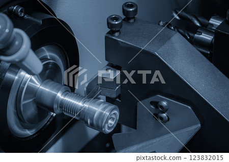 Close up scene the CNC lathe machine slot cutting at the end of brass pipe coupling parts in the light blue scene. Close up scene the CNC lathe machine slot cutting at the end of brass pipe coupling parts in the light blue scene. 123832015