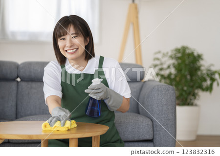 A female cleaning staff member in her 30s smiling at the camera, image of a housekeeping service provider 123832316