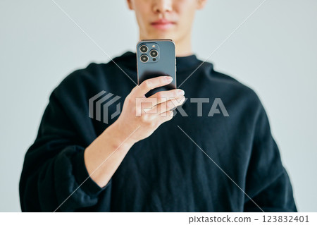 A young man in his twenties operating a smartphone 123832401