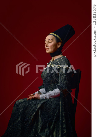 Elder noblewoman in renaissance dress sitting elegantly against deep red background, gazing forward with thoughtful expression. Elder noblewoman in renaissance dress sitting elegantly against deep red background, gazing forward with thoughtful expression. 123832579