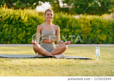 Living a Healthy Lifestyle A Woman Meditating Peacefully in the Great Outdoors Surrounded by Nature 123832644