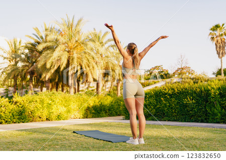 A woman engaging in outdoor exercise, surrounded by lush palm trees, promoting health and wellness 123832650