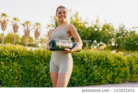 A fit woman practices yoga outdoors, surrounded by lush nature, promoting peace and relaxation A fit woman practices yoga outdoors, surrounded by lush nature, promoting peace and relaxation 123832652