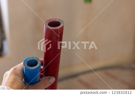 Red and blue pipes of the water supply and heating system. Closeup, selective focus. Red and blue pipes of the water supply and heating system. Closeup, selective focus. 123832812