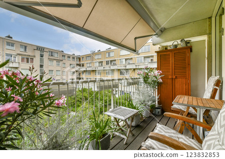 A serene balcony featuring comfortable seating and vibrant plants, creating a relaxing outdoor space for enjoyment and tranquility. 123832853